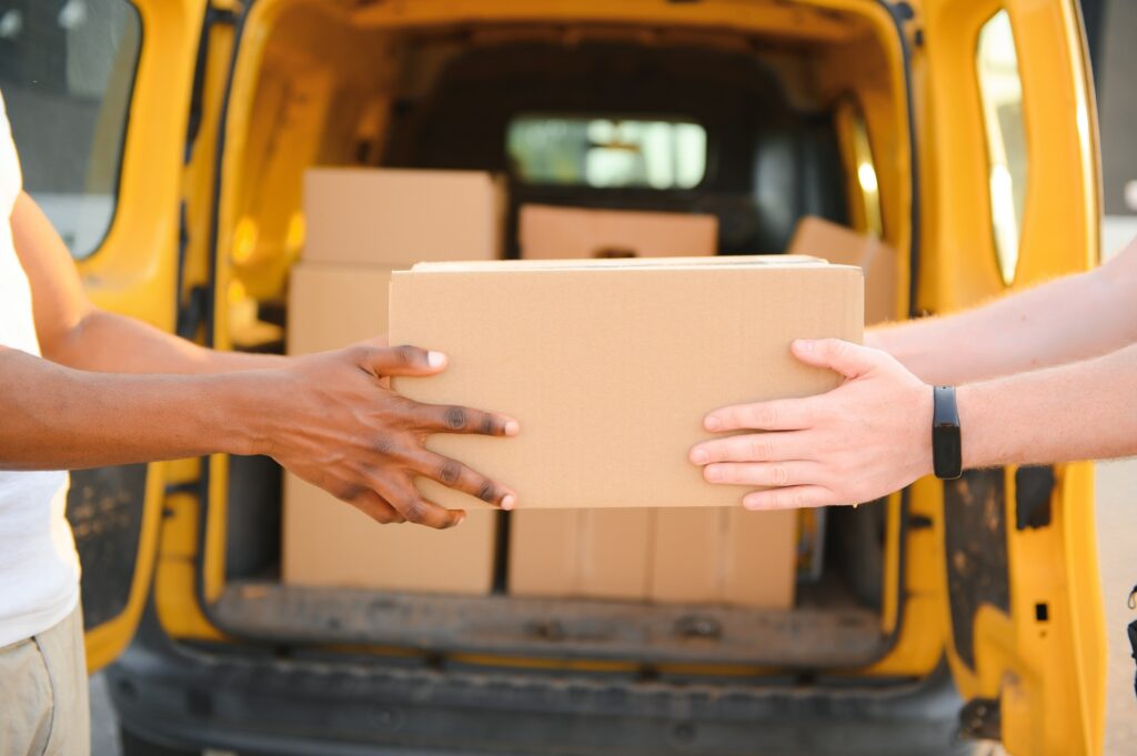 Cropped image of fast delivery service worker giving parcel to the client.
