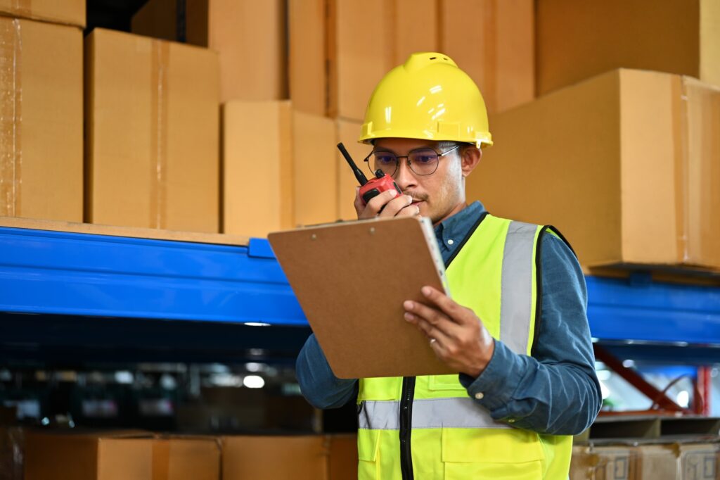 Image of storehouse manager communicating with walkie talkie.